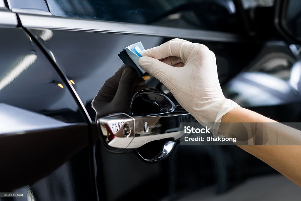 Closeup of hand coating black car door